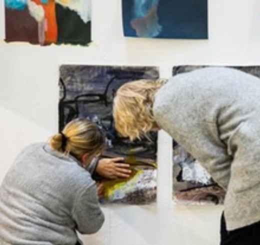 Zwei Frauen betrachten Arbeiten an der Atelierwand