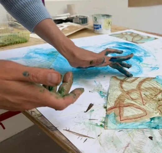 Hände mit Farbe auf Papier